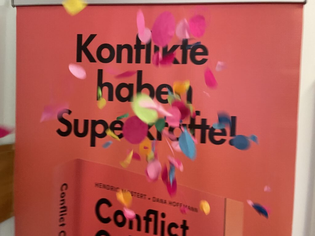 Bild mit Plakat und Headline Konflikte haben Superkräfte